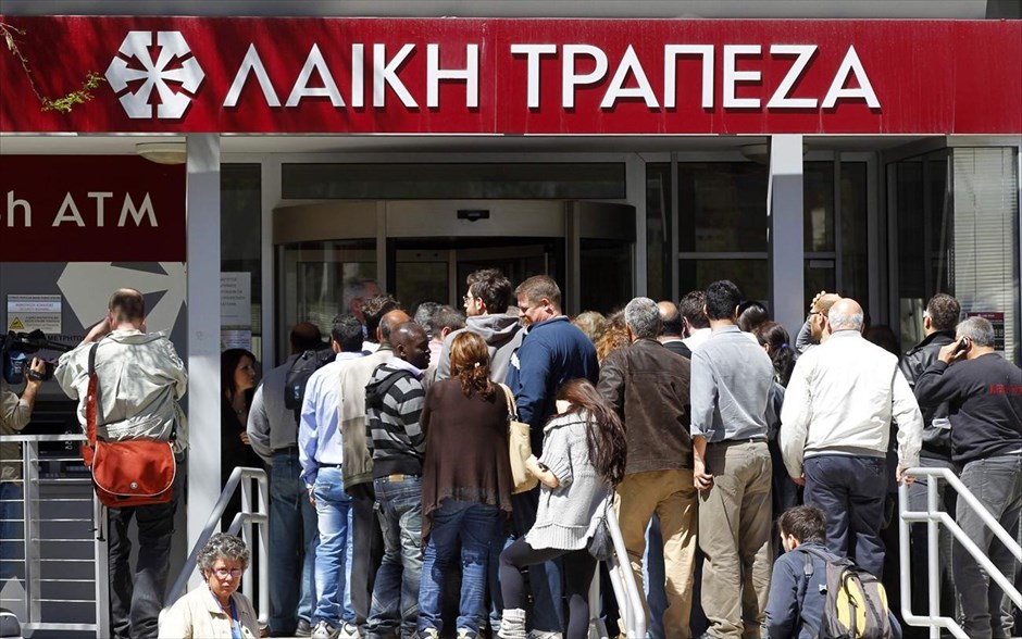 Κύπρος - Λαϊκή Τράπεζα - άνοιξαν οι κυπριακές τράπεζες #19. Κόσμος περιμένει στη σειρά έξω από κατάστημα της Λαϊκής Τράπεζας στη Λευκωσία. Οι κυπριακές τράπεζες άνοιξαν την Πέμπτη για πρώτη φορά έπειτα από σχεδόν δύο εβδομάδες, με αυστηρούς ελέγχους στις συναλλαγές για να αποφευχθεί η φυγή καταθέσεων από τη χώρα.