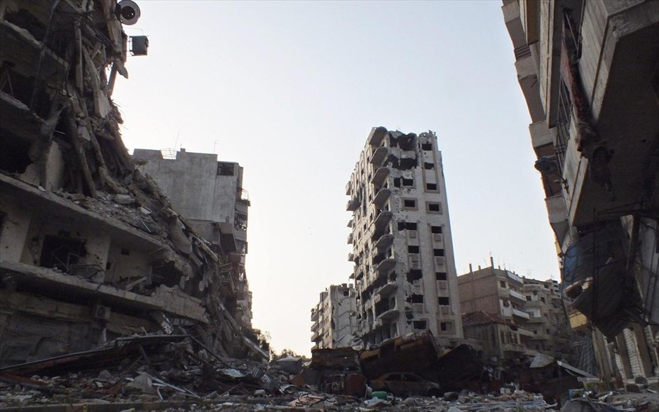 Αεροπορικές επιδρομές στη Συρία. Κατεστραμμένα κτήρια και αυτοκίνητα στην περιοχή Τζουρέτ Αλ Σαγιάχ στη Χομς. 8 Απριλίου 2013.