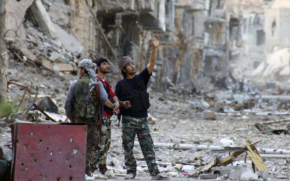 Πόλεις  - συντρίμμια στη Συρία. Μαχητές του Ελεύθερου Συριακού Στρατού κοιτούν τα κατεστραμμένα κτήρια στην περιοχή Ντείρ Αλ-Ζορ της Ανατολικής Συρίας. 7 Απριλίου 2013.