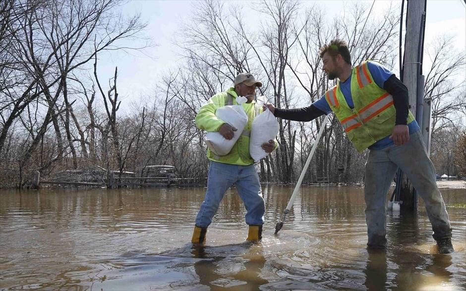 ΗΠΑ: Πλημμύρισε ο ποταμός Μισισιπής #12. Εργάτες μεταφέρουν σάκους με άμμο μετά την πλημμύρα στο Φοξ Λέικ του Ιλινόις. Η στάθμη των νερών του ποταμού Φοξ ανέβηκε επικίνδυνα προκαλώντας πλημμύρες στην ευρύτερη περιοχή μετά τις έντονες βροχοπτώσεις της προηγούμενης εβδομάδας.