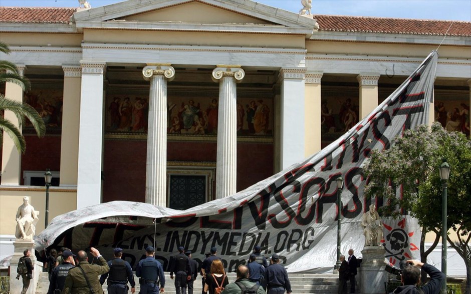Πανό αλληλεγγύης στα Προπύλαια από αντεξουσιαστές για το κλείσιμο του Indymedia. Το πανό και η σημαία αφαιρέθηκαν, ενώ κλήθηκε γερανοφόρο της πυροσβεστικής για να επανατοποθετηθεί στη θέση της η γαλανόλευκη. Το όχημα ωστόσο αποχώρησε πριν τελικά η σημαία επιστρέψει στη θέση της.
