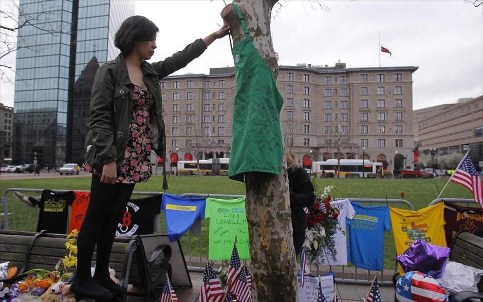 ΗΠΑ: Πενθεί η Βοστόνη #20. Υπάλληλος καταστήματος που βρίσκεται δίπλα από το σημείο της δεύτερης έκρηξης, κρεμάει μία ποδιά στο μνημείο που υπάρχει για τα θύματα της διπλής βομβιστικής επίθεσης στο Μαραθώνιο της Βοστόνης.