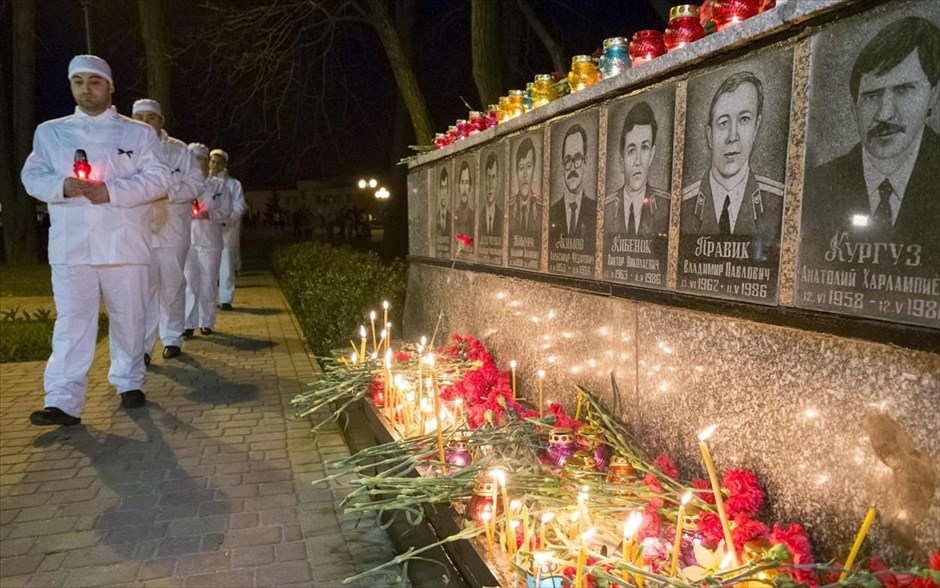 Τσερνόμπιλ: Εκδήλωση μνήμης #1. Προσωπικό του πυρηνικού εργοστασίου του Τσερνόμπιλ ανάβει κεριά στο μνημείο για τους πυροσβέστες και τους εργάτες που έχασαν τη ζωή τους μετά την πυρηνική καταστροφή κατά τη διάρκεια νυχτερινής τελετής κοντά στις εγκαταστάσεις.