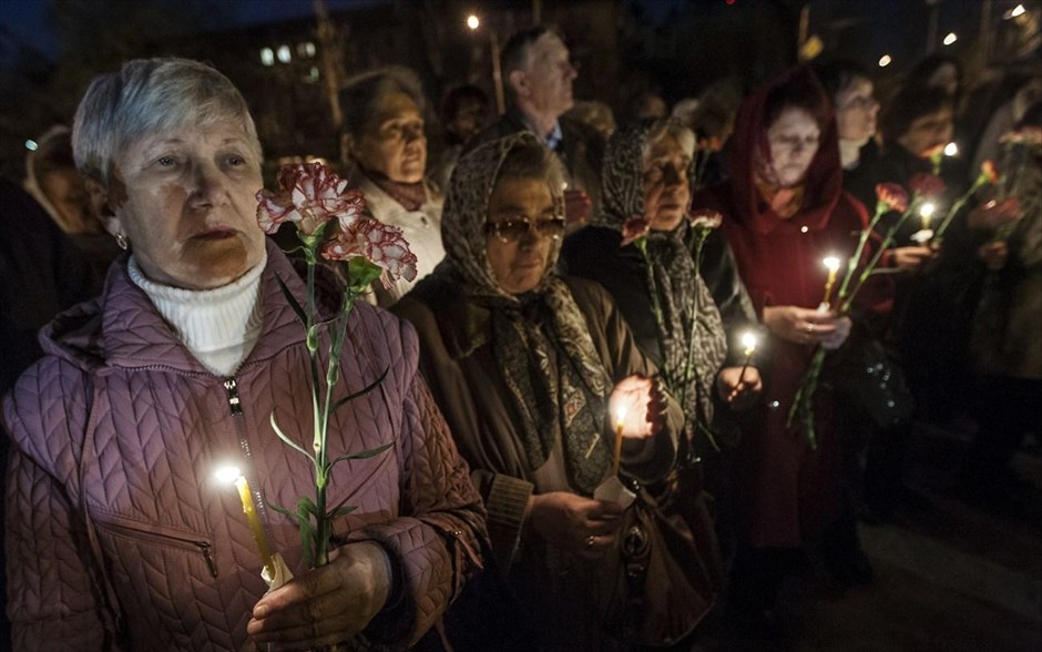 Τσερνόμπιλ: Εκδήλωση μνήμης #14. Γυναίκες κρατούν λουλούδια και κεριά για τα θύματα της πυρηνικής καταστροφής του Τσερνόμπιλ κατά τη διάρκεια τελετής στο Κίεβο.