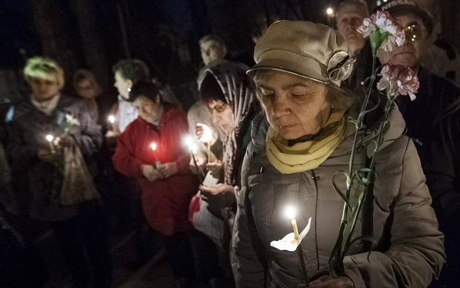 Τσερνόμπιλ: Εκδήλωση μνήμης #16. Γυναίκες κρατούν λουλούδια και κεριά για τα θύματα της πυρηνικής καταστροφής του Τσερνόμπιλ κατά τη διάρκεια τελετής στο Κίεβο.