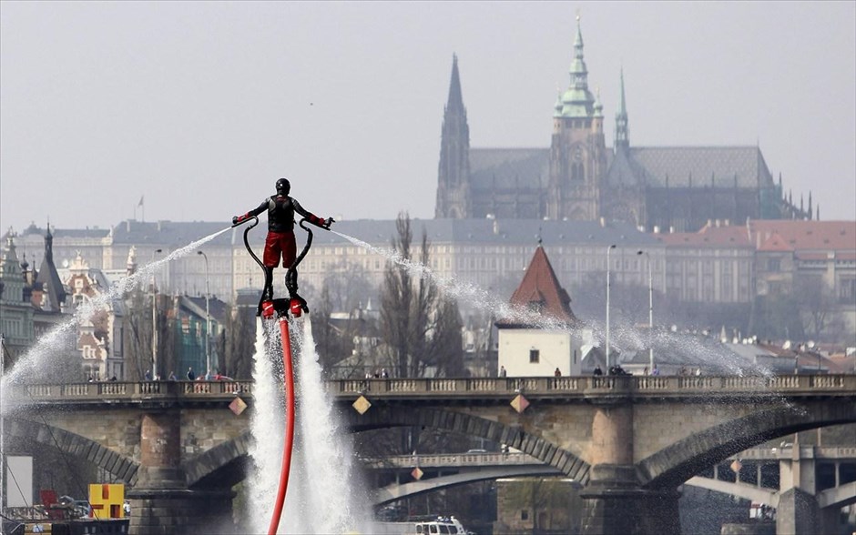 Flyboard στην Πράγα. Ενας άντρας κάνει flyboard στο ποτάμι Βλτάβα, στην Πράγα. Το flyboard είναι ένα δημοφιλές και εντυπωσιακό νέο θαλάσσιο σπορ. Αποτελείται από μια συσκευή η οποία επιτρέπει στον χρήστη της να κάνει εντυπωσιακές κινήσεις και «φιγούρες» μέσα, πάνω και έξω από το νερό, και του δίνει τη δυνατότητα να μπορεί να κινηθεί με τον ίδιο τρόπο που κινούνται τα δελφίνια.