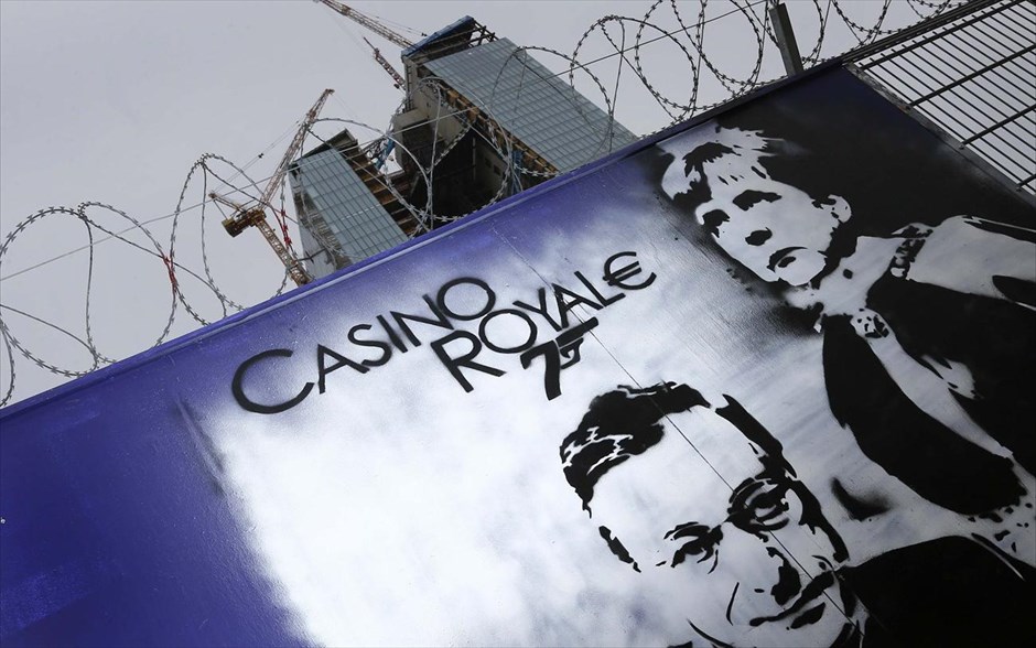 Casino Royal€. Γκράφιτι που απεικονίζει τον επικεφαλής της Ευρωπαϊκής Κεντρικής Τράπεζας, Μάριο Ντράγκι, και την γερμανίδα καγκελάριο Ανγκελα Μέρκελ έώ από το εργοτάξιο του&nbsp; νέου κτηρίου της ΕΚΤ στη Φρανκφούρτη.