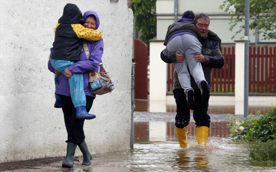 Γερμανία - Στο έλεος εκτεταμένων πλημμυρών η κεντρική Ευρώπη #7. Κάτοικοι έχοντας στα χέρια τους τα παιδιά τους, περπατούν σε ένα πλημμυρισμένο δρόμο&nbsp; στην πόλη Γκρίμα, κοντά στη Λειψία.