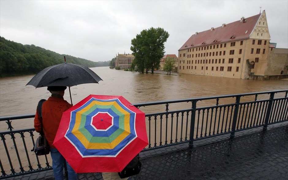 Γερμανία - Στο έλεος εκτεταμένων πλημμυρών η κεντρική Ευρώπη #10. Κόσμος κοιτάζει από μία γέφυρα τον υπερχειλισμένο ποταμό Μούλντε στην πόλη Γκρίμα κοντά στη Λειψία..