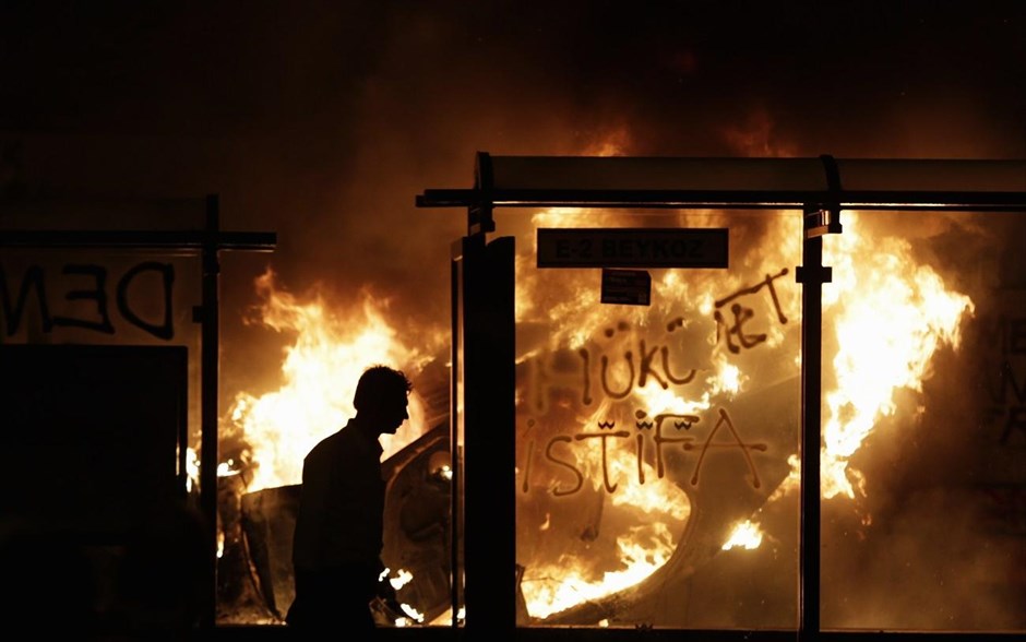 Τουρκία: Αλλη μια νύχτα συγκρούσεων #6. Διαδηλωτής περνά δίπλα από φλεγόμενο όχημα στην πλατεία Ταξίμ, στο κέντρο της Κωνσταντινούπολης.