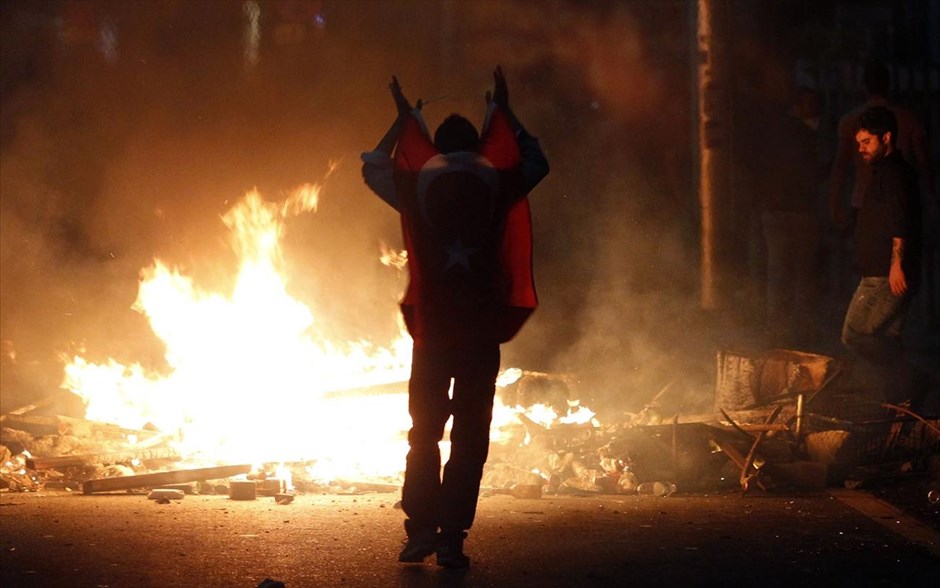 Τουρκία: Αλλη μια νύχτα συγκρούσεων #10. Διαδηλωτής κρατάει τη σημαία της Τουρκίας κατά τη διάρκεια συγκρούσεων με τις αστυνομικές δυνάμεις στην Αγκυρα.