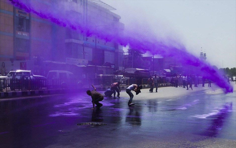 Μωβ νερό κατά διαδηλωτών . Ρίχνοντας μωβ νερό, η αστυνομία προσπαθεί να διαλύσει μία συγκέντρωση διαμαρτυρίας κυβερνητικών υπαλλήλων στο Κασμίρ, της Ινδίας.