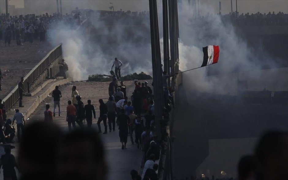 Αίγυπτος - Κάιρο - Διαδηλωτές. Μέλη της Μουσουλμανικής Αδελφότητας και υποστηρικτές του Μόρσι απομακρύνονται από τα δακρυγόνα που έχουν πετάξει μέλη των δυνάμεων ασφαλείας, σε μία γέφυρα που οδηγεί στην πλατεία Ραμπάα Ανταουΐγια του Καΐρου.