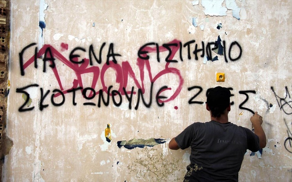 Διαμαρτυρία για το θάνατο 19χρονου. Διαδηλωτής γράφει συνθήματα σε τοίχο, με αφορμή τον θάνατο του 19χρονου.&nbsp;