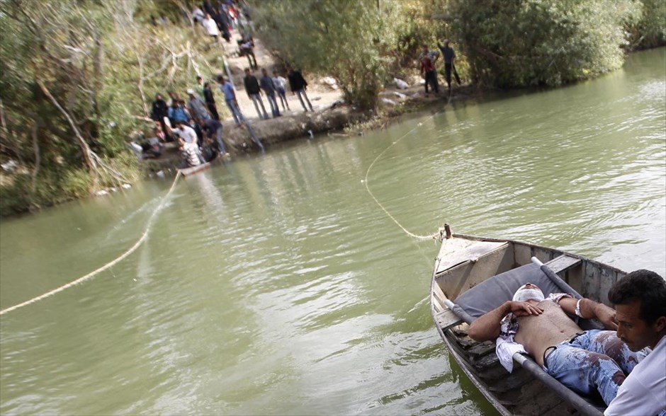 Συρία: Η κάθοδος στο χάος #14. Σύρος τραυματίας μεταφέρεται με βάρκα στην Τουρκία από τον ποταμό Ορόντες στα τουρκοσυριακά σύνορα. (10 Οκτωβρίου 2012)