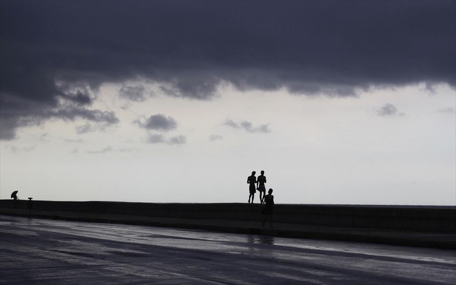 Σύννεφα στον ουρανό της Αβάνας . Σύννεφα συγκεντρώνονται στον ουρανό της Αβάνας, την ώρα που κουβανοί κάνουν βόλτα στην παραλιακή λεωφόρο Ελ Μαλεκόν της Κουβάς.