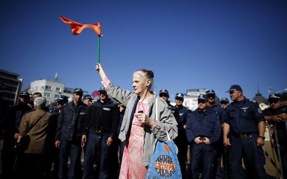 Συνεχίζονται οι διαδηλώσεις στη Σόφια. Διαδηλώτρια κρατά μία σημαία κατά τη διάρκεια διαμαρτυρίας μπροστά από το κτήριο της βουλγαρικής Βουλής στη Σόφια. Οι διαδηλώσεις εναντίον του υπουργικού συμβουλίου ξέσπασαν δύο εβδομάδες μετά την ανάληψη των καθηκόντων του στα τέλη του Μαΐου. Ο διορισμός ενός μεγιστάνα των ΜΜΕ σε θέση ασφαλείας, υπήρξε για πολλούς παράδειγμα του ελέγχου των κρατικών υπηρεσιών από τα ισχυρά ιδιωτικά συμφέροντα. Η κυβέρνηση πήρε πίσω το διορισμό, αλλά δεν κατάφερε να καταστείλει τη λαϊκή οργή κατά της διαφθοράς στη φτωχότερη χώρα της Ευρωπαϊκής Ένωσης, η οποία έγινε μέλος της ευρωπαϊκής οικογένειας το 2007, αλλά αγωνίζεται ακόμη να ανταποκριθεί στα πρότυπά της 