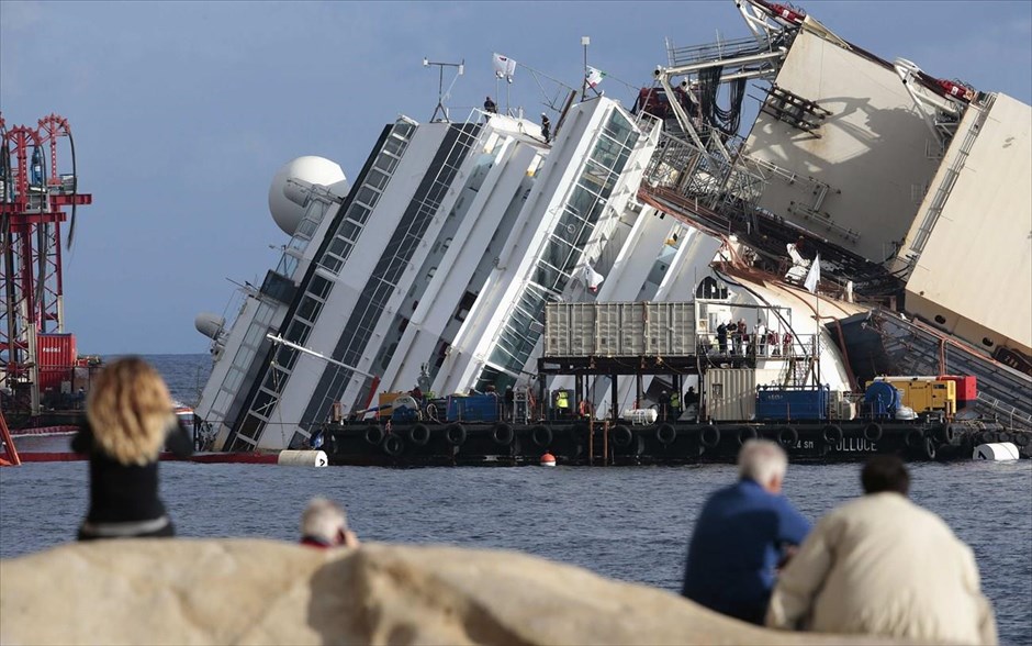 Επιχείρηση ανέλκυσης του Costa Concordia 14. Άνθρωποι κοιτάζουν το ναυαγισμένο πλοίο Costa Concordia.