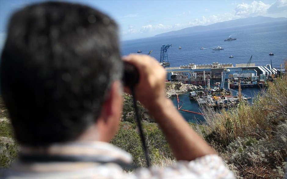 Επιχείρηση ανέλκυσης του Costa Concordia 15. Ένας άνδρας παρακολουθεί με τα κιάλια του την επιχείρηση ανέλκυσης του Costa Concordia.