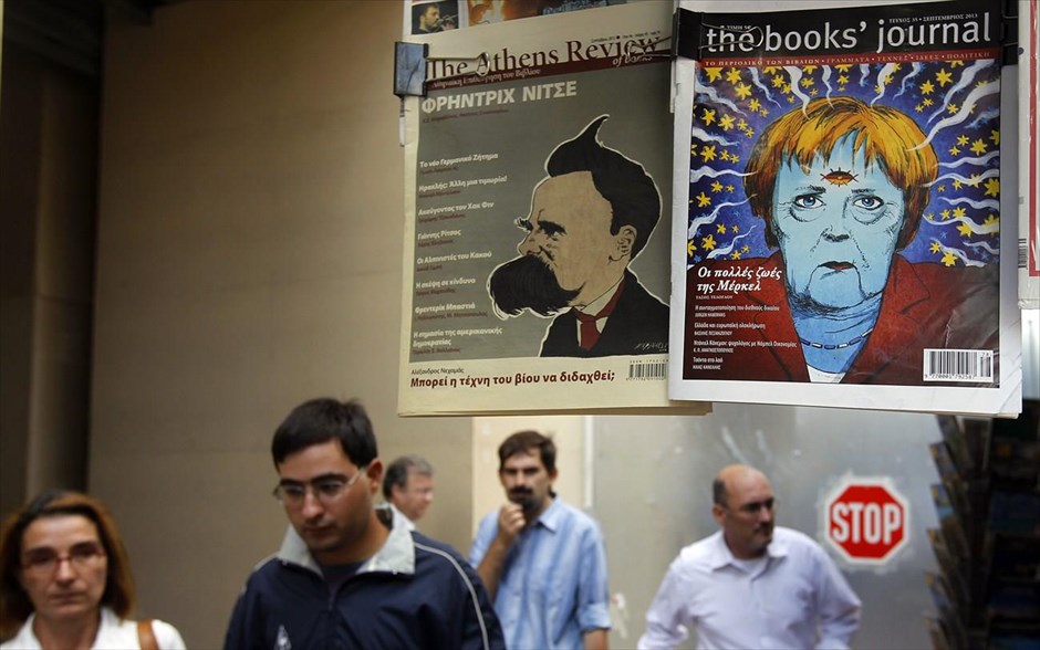 Τα πρωτοσέλιδα των εφημερίδων για τις γερμανικές εκλογές. Περαστικοί προσπερνούν κιόσκι εφημερίδων σε κεντρικό δρόμο της Αθήνας. Τα πρωτοσέλιδα του ελληνικού Τύπου σήμερα έιναι αφιερωμένα στις γερμανικές εκλογές με φωτογραφίες ή σκίτσα της Καγκελάριου Ανγκελα Μέρκελ.