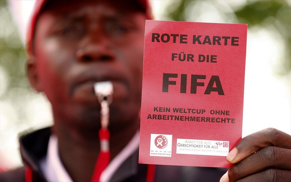Ελβετία: Διαμαρτυρία έξω από τα γραφεία της FIFA. Μέλος της εργατικής ένωσης UNIA δείχνει μία κόκκινη κάρτα κατά τη διάρκεια διαμαρτυρίας μπροστά από κεντρικά γραφεία της Διεθνούς Συνομοσπονδίας Ποδοσφαίρου (FIFA) στην Ζυρίχη. Το Κατάρ έχει δεχθεί έντονη κριτική για τον τρόπο με τον οποίο αντιμετωπίζονται οι μετανάστες εργάτες έπειτα από έρευνα του βρετανικού Guardian.