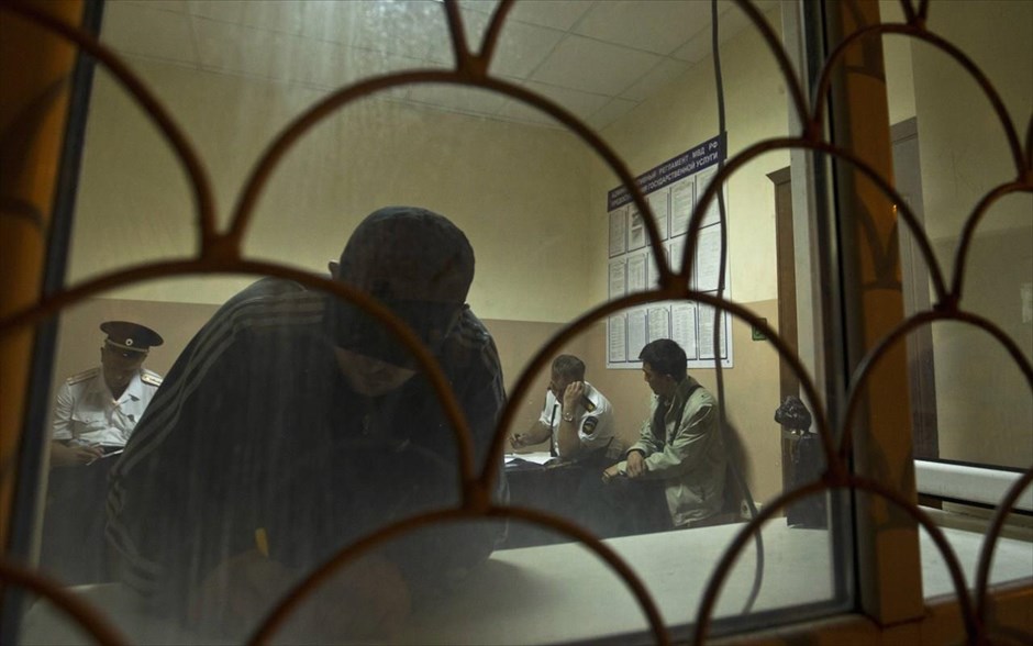 Αντίστροφη μέτρηση για τους Χειμερινούς Ολυμπιακούς Αγώνες στο Σότσι #20. Αστυνομικοί συμπληρώνουν έγγραφα μεταναστών εργατών που βρίσκονται υπό κράτηση, μετά από επιχείρηση «σκούπα» των αρχών, σε ένα αστυνομικό τμήμα στο Σότσι.