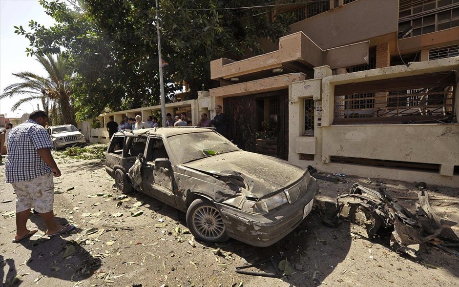 Έκρηξη βόμβας στη Βεγγάζη. Περαστικοί κοιτάζουν ένα καταστραμμένο αυτοκίνητο έξω από το προξενείο της Σουηδίας στη Βεγγάζη. Παγιδευμένο αυτοκίνητο εξερράγη την Παρασκευή έξω από το προξενείο της Σουηδίας στην πόλη της ανατολικής Λιβύης, προκαλώντας ζημίες στην πρόσοψη του κτηρίου και σε κατοικίες γύρω του.
