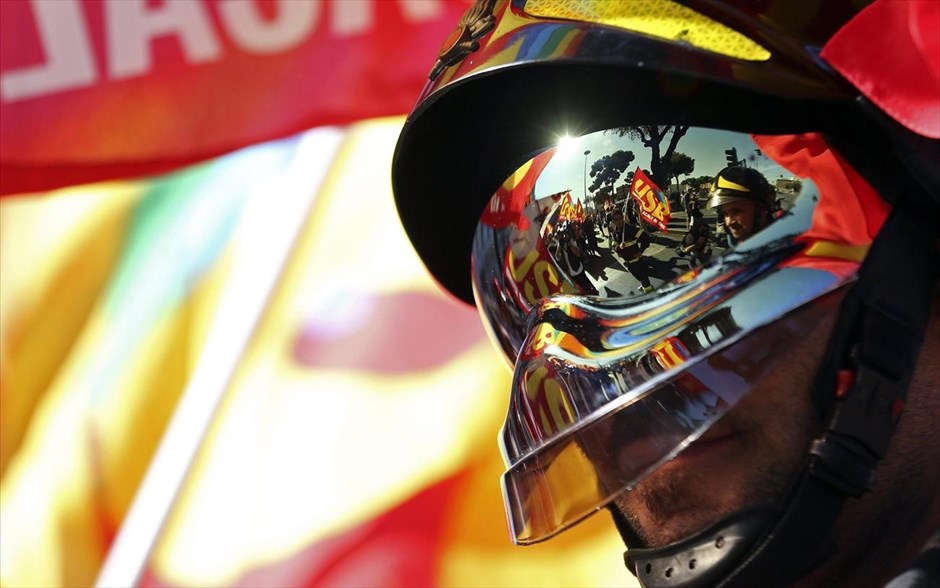 Απεργιακές συγκεντρώσεις στην Ιταλία. Πυροσβέστες που κρατούν σημαίες της συνδικαλιστικής οργάνωσης USB διακρίνονται στην αντανάκλαση του κράνους συναδέλφου τους, κατά τη διάρκεια αντικυβερνητικής διαδήλωσης στη Ρώμη. Δημόσιοι υπάλληλοι, νοσοκομειακό προσωπικό και εργαζόμενοι στις μεταφορές προχώρησαν σε απεργία την Παρασκευή εναντίον της κυβέρνησης του Ενρίκο Λέτα, διαμαρτυρόμενοι για το πάγωμα των μισθών στο δημόσιο τομέα και την ανεπαρκή ελάφρυνση της φορολογικής επιβάρυνσης των εργαζομένων.