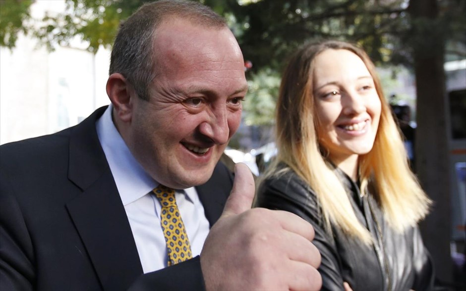 Γεωργία: Συντριπτική νίκη του Γκεόργκι Μαργκελασβίλι δείχνουν τα exit poll. Ο προεδρικός υποψήφιος Γκεόργκι Μαργκελασβίλι, με την κόρη του Άνα χαμογελά έξω από ένα εκλογικό κέντρο, κατά τη διάρκεια των προεδρικών εκλογών στην Τιφλίδα. Ο Μαργκελασβίλι, σύμμαχος του δισεκατομμυριούχου επιχειρηματία και πρωθυπουργού Μπιτζίνα Ιβανισβίλι, φαίνεται να οδεύει προς συντριπτική νίκη στις προεδρικές εκλογές οι οποίες διεξήχθησαν την Κυριακή στη Γεωργία, σύμφωνα με τα exit poll.