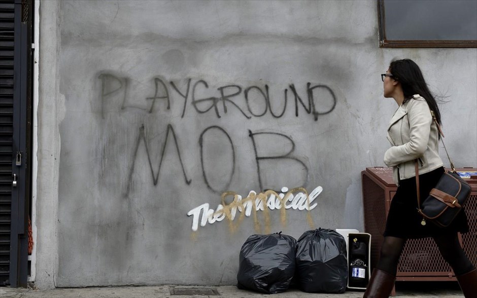 O Banksy κατακτά τη Νέα Υόρκη #3. Μία γυναίκα περνά μπροστά από ένα γκράφιτι του Βρετανού καλλιτέχνη δρόμου Banksy, στη Νέα Υόρκη, 09 Οκτωβρίου 2013.
