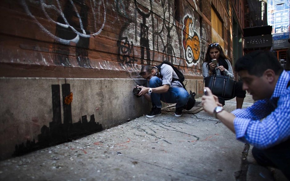 O Banksy κατακτά τη Νέα Υόρκη #12. Κόσμος φωτογραφίζει έργο του Banksy στο Lower Manhattan της Νέας Υόρκης, 15 Οκτωβρίου 2013.