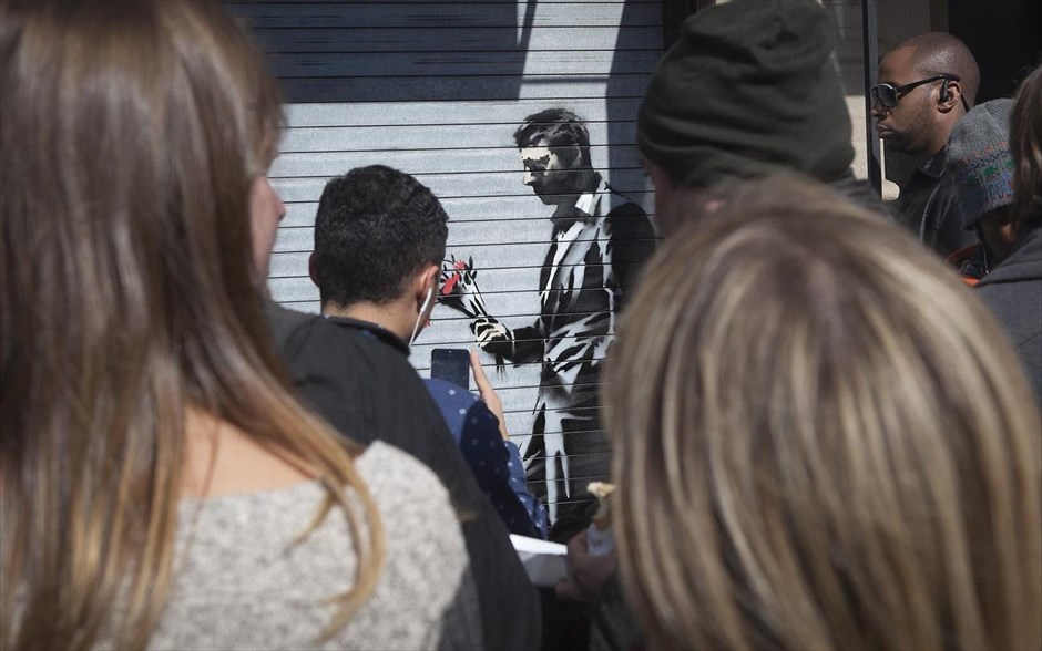 O Banksy κατακτά τη Νέα Υόρκη #25. Κόσμος βγάζει φωτογραφίες το νέο γκράφιτι του Banksy έξω από το Hustler Club στηΝέα Υόρκη, 24 Οκτωβρίου 2013.