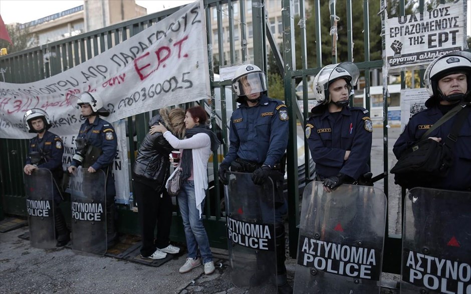 Επέμβαση της αστυνομίας στην ΕΡΤ - reuters. Πρώην εργαζόμενοι στην ΕΡΤ βρίσκονται στην είσοδο του ραδιομεγάρου, δίπλα από τις αστυνομικές δυνάμεις που φρουρούν το χώρο.