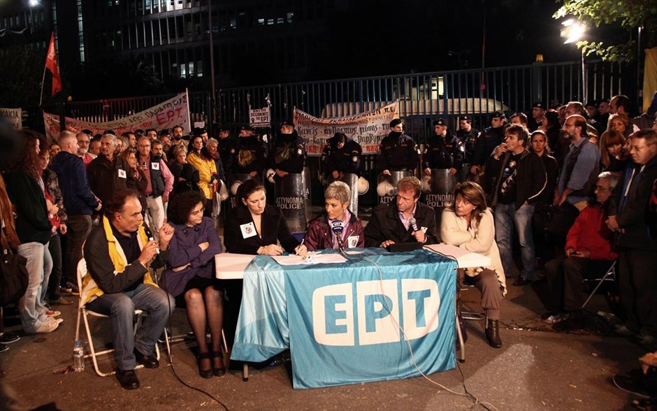 Δελτίο ειδήσεων από την ΕΡΤ σε αυτοσχέδιο «στούντιο». Δελτίο ειδήσεων από την ΕΡΤ σε αυτοσχέδιο “στούντιο” ακριβώς έξω από την κεντρική πύλη με τα ΜΑΤ που την φυλάνε να λειτουργούν ως φόντο.