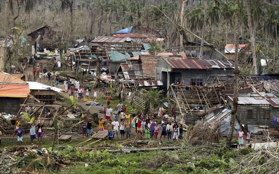 Φιλιππίνες - τυφώνας Χαϊγιάν. Επιζώντες του τυφώνα Χαϊγιάν καλωσορίζουν ένα ελικόπτερο της πολεμικής αεροπορίας των Φιλιππινών, το οποίο πλησιάζει το απομακρυσμένο χωριό στο οποίο δεν υπάρχει πρόσβαση με οχήματα, για να παραδώσει τρόφιμα, 25 περίπου χλμ δυτικά του Ταμπλοκάν.