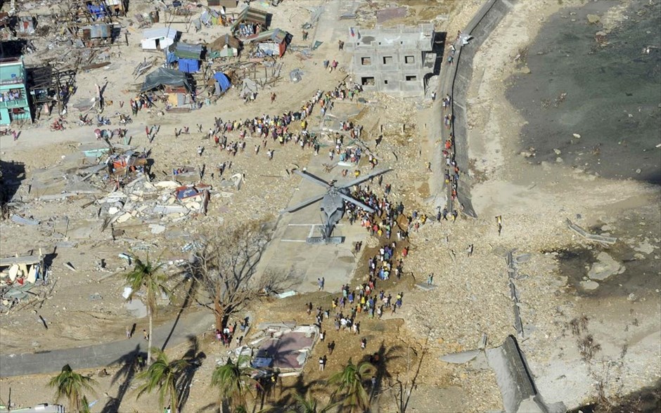 Φιλιππίνες - τυφώνας Χαϊγιάν. Φιλιππινέζοι πολίτες έχουν μαζευτεί γύρω από ένα ελικόπτερο Sea Hawk για να παραλάβουν προμήθειες ανθρωπιστικής βοήθειας στο Γκουιουάν, στις Φιλιππίνες.