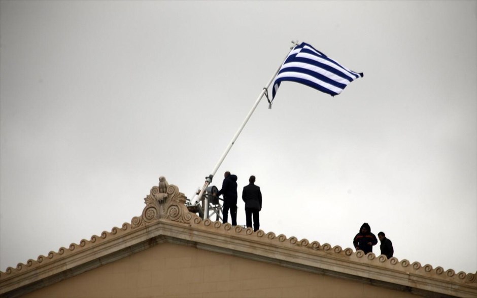 Δυνατός αέρας «ξήλωσε» την ελληνική σημαία από τη Βουλή. Ο δυνατός αέρας έριξε την ελληνική σημαία από τον ιστό που είναι στην κορυφή του κτηρίου του Κοινοβουλίου την Τρίτη. Στο στιγμιότυπο συνεργείο εργατών αποκαθιστούν την σημαία στον ιστό της.