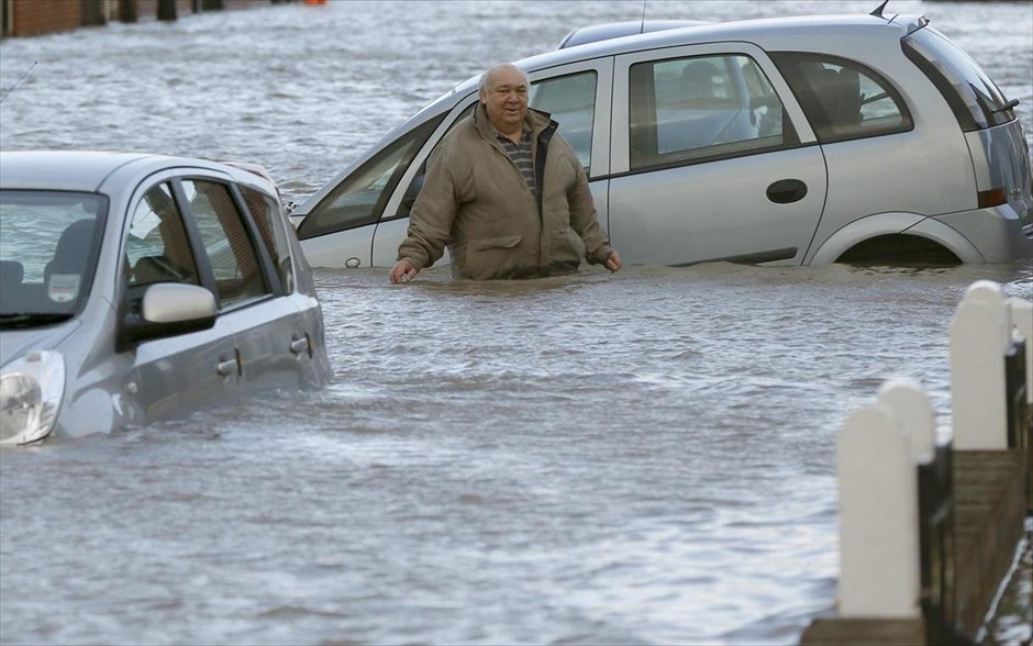  Η καταιγίδα Ξάβερ πλήττει τη βορειοδυτική Ευρώπη #1. Ένας άνδρας προσπαθεί να διασχίσει έναν πλημμυρισμένο δρόμο στην πόλη Rhyl της βόρειας Ουαλίας.