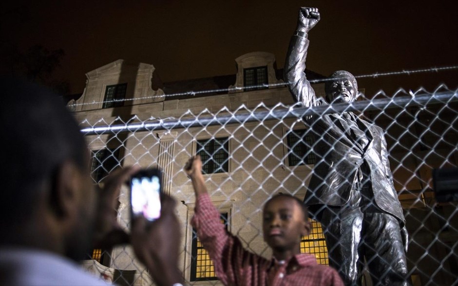 Συγκίνηση για τον θάνατο του Μαντέλα. Αμερικανοί πολίτες φωτογραφίζονται μπροστά από το άγαλμα του Μαντέλα στην πρεσβεία της Νότιας Αφρικής στην Ουάσινγκτον.