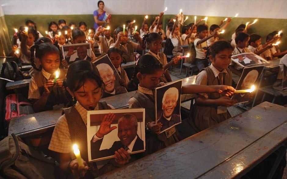 Νέλσον Μαντέλα. Μαθήτριες κρατούν κεριά και φωτογραφίες του Νέλσον Μαντέλα κατά τη διάρκεια προσευχής στη μνήμη του σε σχολείο της πόλης Αχμενταμπάντ στην Ινδία.