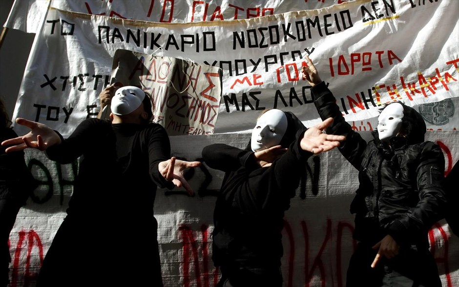 POY - Φωτογραφίες της χρονιάς - Νοέμβριος 2013. Εργαζόμενες σε Ψυχιατρικό Νοσοκομείο της Αθήνας ντυμένες στα μαύρα, με λευκές μάσκες στα πρόσωπά σε παντομίμα αναπαριστούν τις αντιδράσεις που προκαλούν οι πολιτικές του υπουργού Υγείας, κατά τη διάρκεια συγκέντρωσης διαμαρτυρίας έξω απο το υπουργείο υγείας. 29 Νοεμβρίου 2013