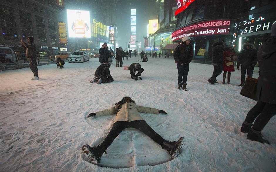 ΗΠΑ - κακοκαιρία - χιόνι - Times Square. Μία γυναίκα σχηματίζει «αγγέλους από χιόνι» στην Times Square της Νέας Υόρκης.