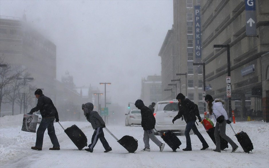 Σφοδρές χιονοπτώσεις παρέλυσαν τις ΗΠΑ. Ταξιδιώτες φεύγουν από σταθμό τρένου στη χιονισμένη Βοστόνη.