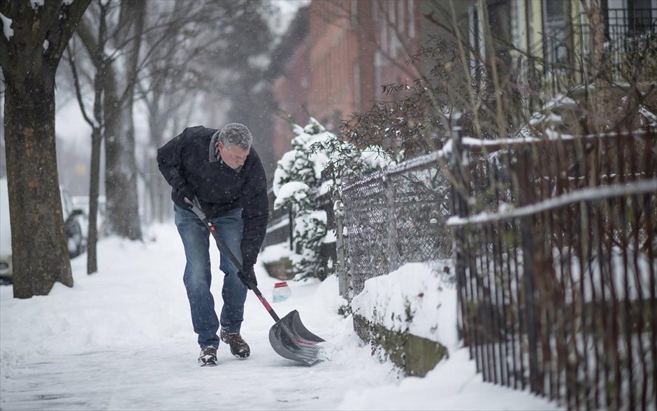 Σφοδρές χιονοπτώσεις παρέλυσαν τις ΗΠΑ. Ο νέος δήμαρχος της Νέας Υόρκης, Μπίλ ντε Μπλάζιο καθαρίζει το πεζοδρόμιο έξω από την κατοικία του.