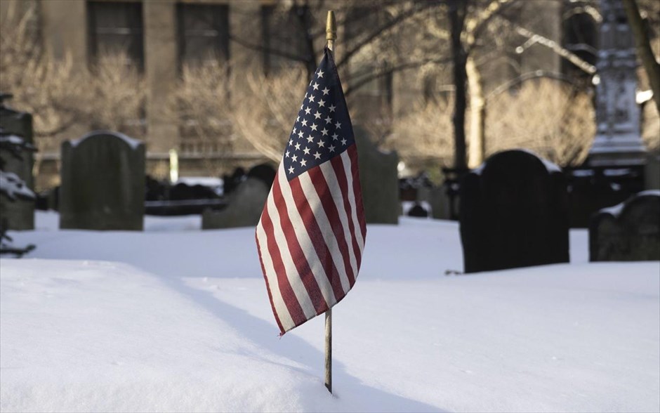 Σφοδρές χιονοπτώσεις παρέλυσαν τις ΗΠΑ. Η σημαία των ΗΠΑ, ανάμεσα σε πυκνό χιόνι σε νεκροταφείο της Νέας Υόρκης. 