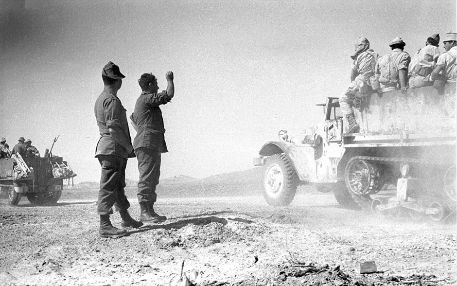 Ισραήλ - Αριέλ Σαρόν - Οκτώβριος 1956. Ο Αριέλ Σαρόν (2ος αριστερά) παρακολουθεί στρατιώτες που περνούν από μπροστά του, στην χερσόνησο του Σινά, κατά τη διάρκεια του πολέμου με την Αίγυπτο το 1956 (30 Οκτωβρίου 1956). Η φωτογραφία δόθηκε στη δημοσιότητα από το ισραηλινό υπουργείο Άμυνας.