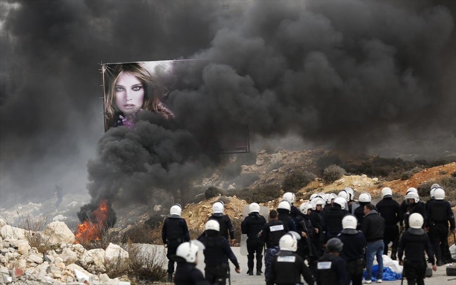 Ένταση στους προσφυγικούς καταυλισμούς της Δυτικής Όχθης. Παλαιστίνιοι αστυνομικοί στέκονται δίπλα σε φλεγόμενα δέντρα έξω από προσφυγικό καταυλισμό στη Δυτική Όχθη. Τουλάχιστον 50 άνθρωποι τραυματίστηκαν την Κυριακή σε συγκρούσεις μεταξύ αστυνομικών και κατοίκων καταυλισμών, οι οποίοι διαμαρτύρονται για το «πάγωμα» των υπηρεσιών που έχει επιφέρει η απεργία διάρκειας ενός μήνα των εργαζομένων της UNRWA. Οι εργαζόμενοι της υπηρεσίας του ΟΗΕ που είναι υπεύθυνη για τη λειτουργία των καταυλισμών, ζητούν υψηλότερους μισθούς.
