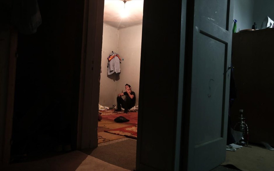 Τα «Προσφυγικά» της λεωφόρου Αλεξάνδρας. Ένας μετανάστης καπνίζει το τσιγάρο του μέσα σε διαμέρισμα των «Προσφυγικών».