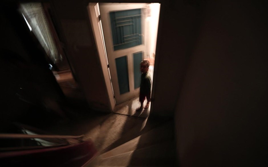 Τα «Προσφυγικά» της λεωφόρου Αλεξάνδρας. Ένα παιδί μεταναστών στέκεται στην είσοδο ενός διαμερίσματος.