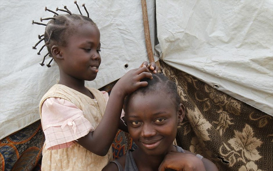 Κορίτσια σε στρατόπεδο προσφύγων στην Κεντροαφρικανική Δημοκρατία. Κοριτσάκι από την Κεντροαφρικανική Δημοκρατία πλέκει τα μαλλιά της αδερφή της ενώ βρίσκονται σε ένα στρατόπεδο προσφύγων στο Διεθνές Αεροδρόμιο του Μπανγκί.Μετά την εκδίωξη του κ. Τζοτόντια από την εξουσία τον Ιανουάριο, του οποίου το κατά πλειοψηφία μουσουλμανικό κίνημα κατηγορήθηκε για πολλές ωμότητες σε βάρος χριστιανικών πληθυσμών, η χώρα βυθίστηκε σε ένα φαύλο κύκλο διαθρησκευτικής βίας, με την εμφάνιση των Αντι-Μπαλάκα, των πολιτοφυλακών αυτοάμυνας χριστιανών, αποφασισμένων να εκδικηθούν τους Σελέκα ως μουσουλμάνους πολίτες.